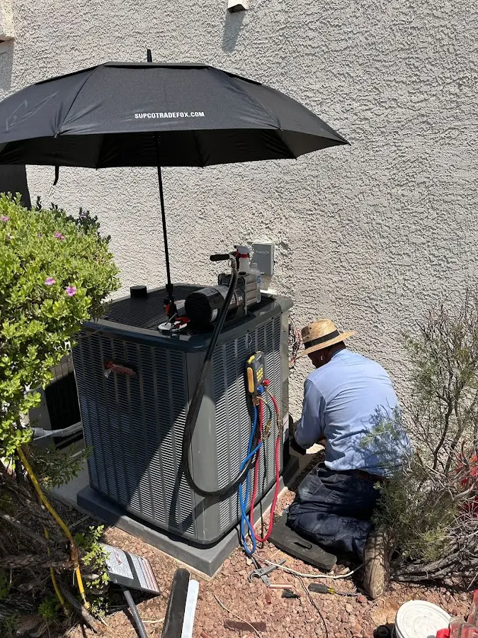 HVAC technician performing outdoor AC maintenance in Beeville